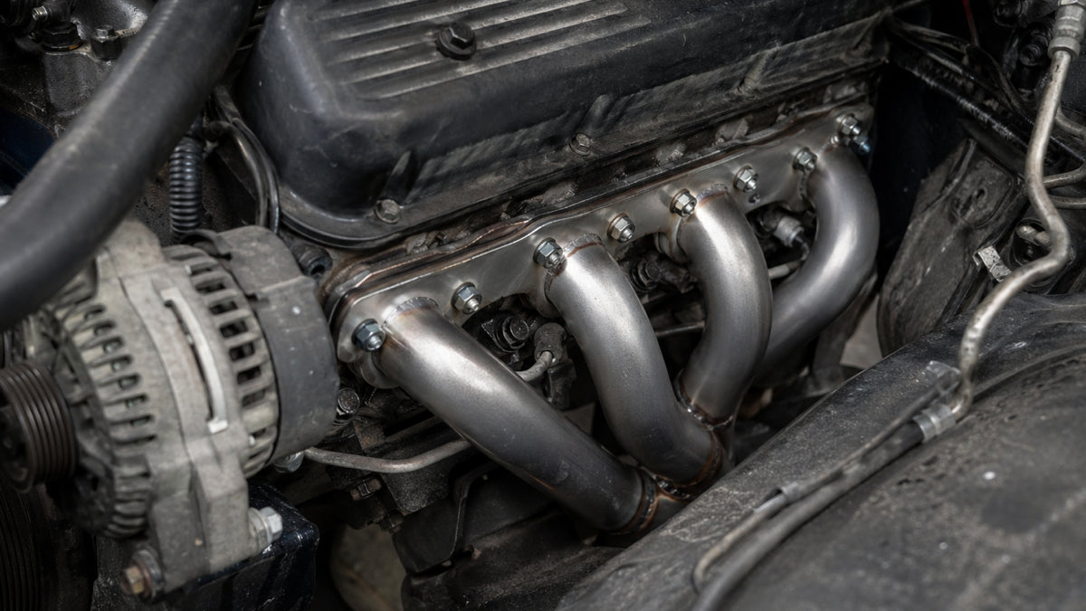 Stainless steel exhaust headers installed on a V8 engine in engine bay